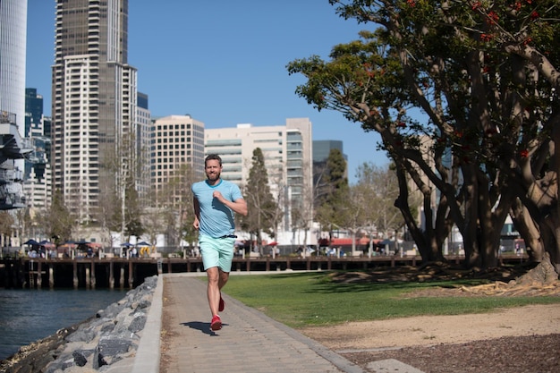 Foto atletische jonge hardloper stedelijke sport man joggen en rennen voor fitness in de stad op een mooie zomerdag