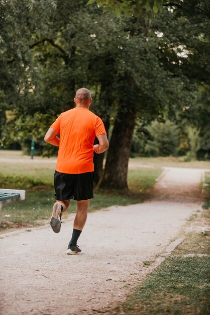 Atletische jonge man loopt in de natuur Gezonde levensstijl