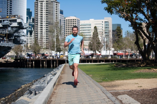 Atletische jonge man loopt in de natuur rennen in stadspark
