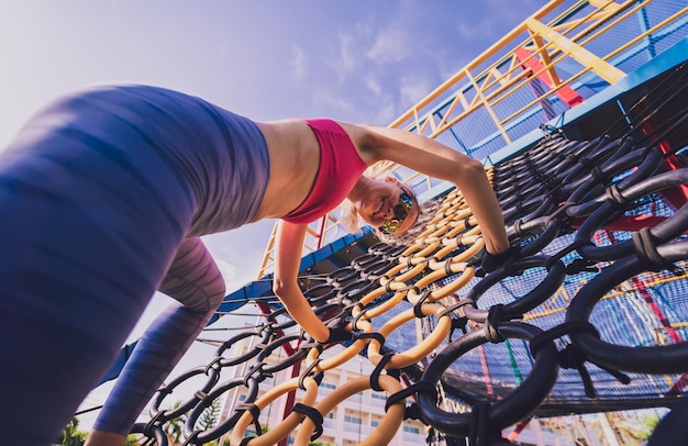 Atletische jonge vrouw die traint in het touw trainingskamp