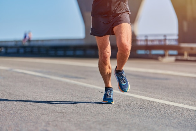 Atletische man joggen in sportkleding op weg van de stad