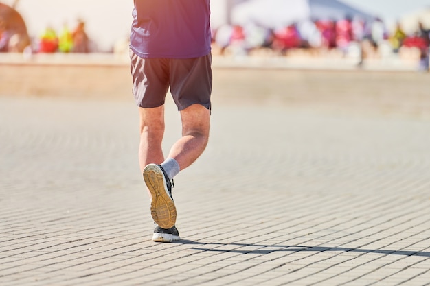 Atletische man joggen in sportkleding op weg van de stad