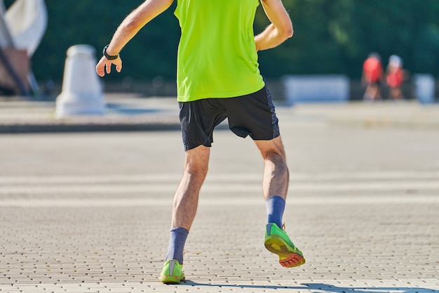 Atletische man joggen in sportkleding op weg van de stad