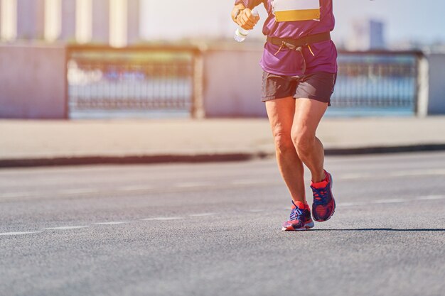 Atletische man joggen in sportkleding op weg van de stad