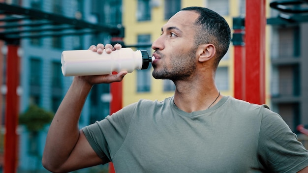 Atletische man Latijns-Amerikaanse sportman voelen warme drank koud zoet water gezonde eiwit drank