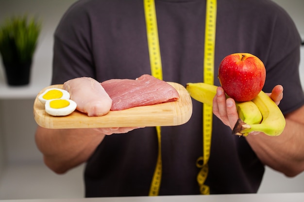 Atletische man met een bord met vlees voor de juiste voeding van de atleet