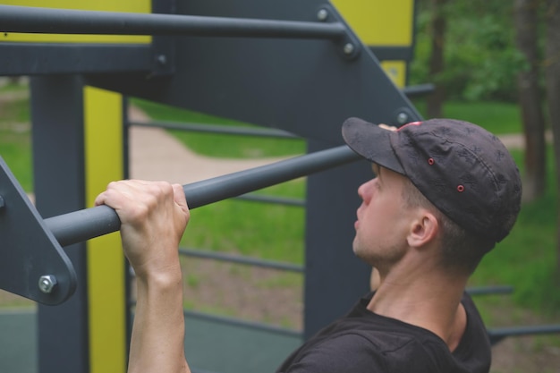 atletische man trekt aan de rekstok in het park in het bos buitentraining