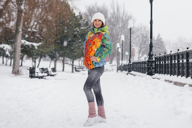 atletische meisje vormt op een ijzige en besneeuwde dag. Fitness, hardlopen