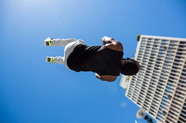 Atletische mens die achterflip in de stad doet