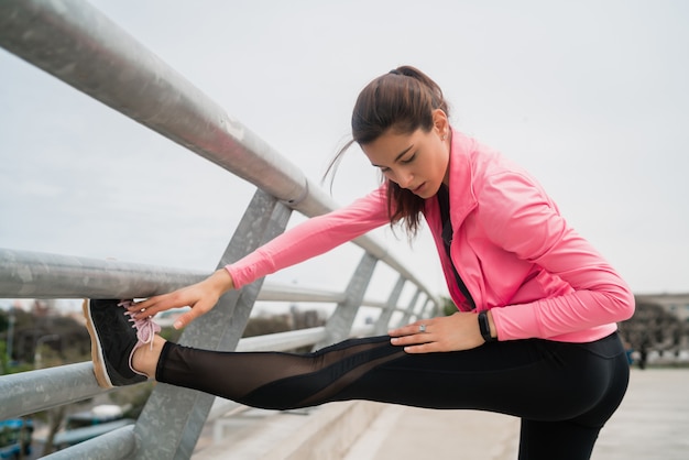 Atletische vrouw benen strekken voor het sporten.