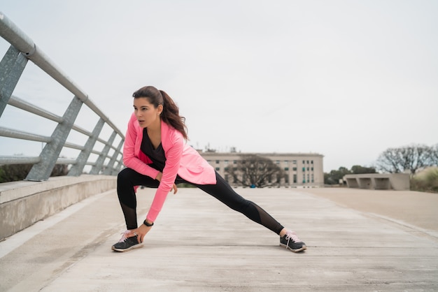 Atletische vrouw benen strekken voor het sporten.