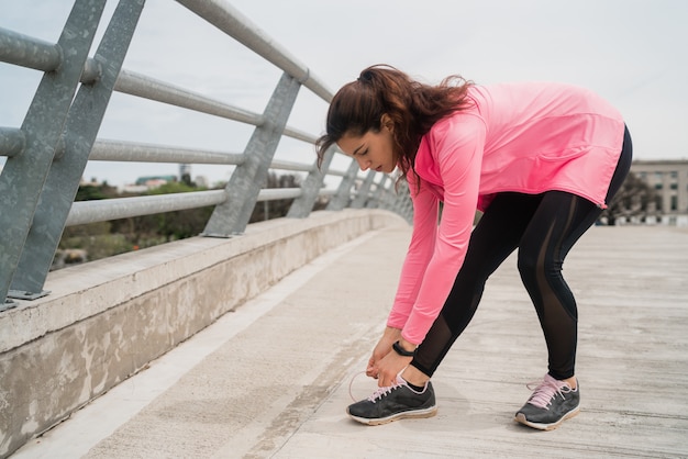 Atletische vrouw die haar schoenveters bindt