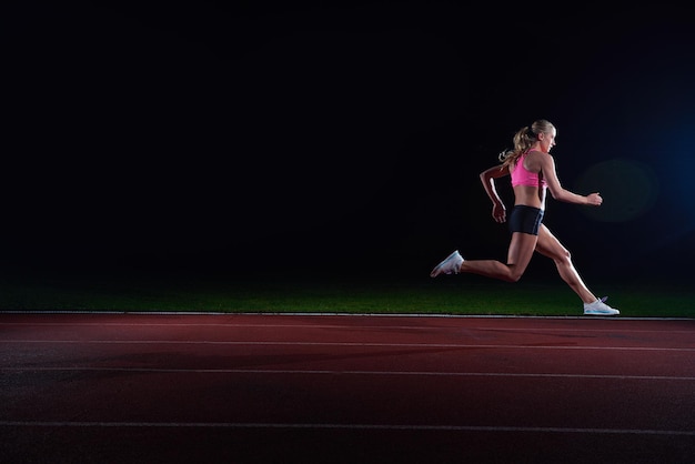 Atletische vrouw die op het circuit loopt