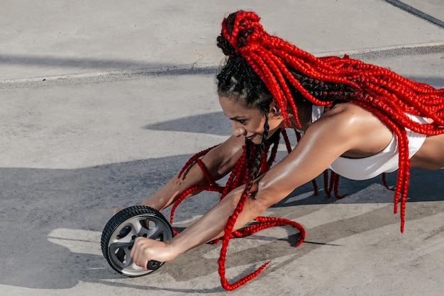 Atletische vrouw doet oefeningsoefening met een rol Kracht en motivatie Foto van sportieve vrouw in modieuze sportkleding