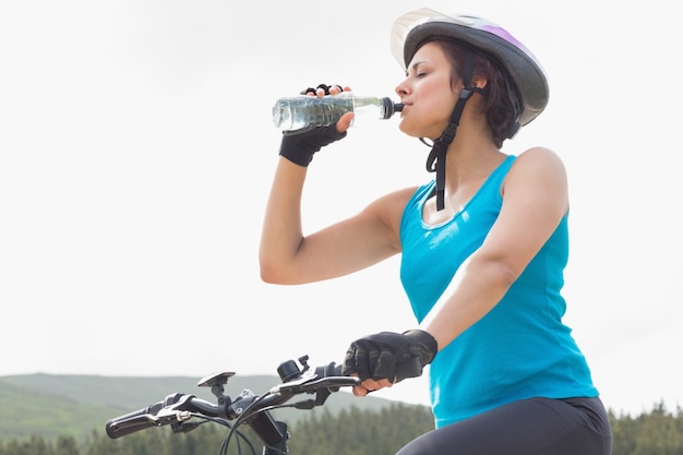 Atletische vrouw op het drinkwater van de bergfiets