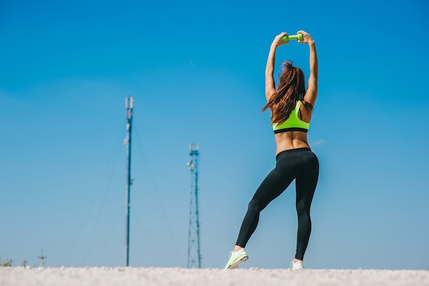 atletische vrouw oppompen spieren met halters