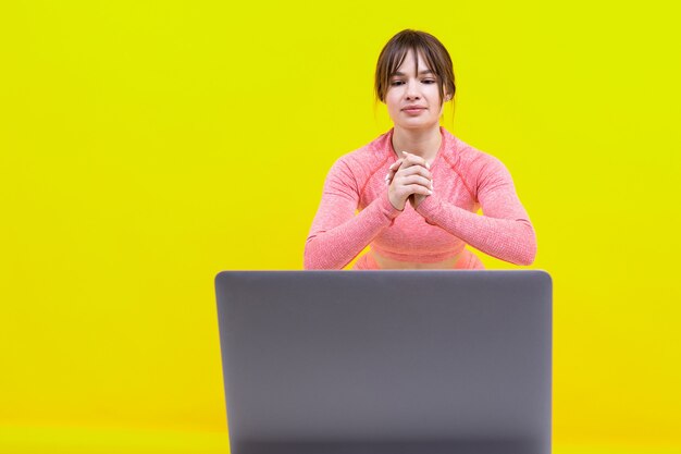Atletische vrouw traint thuis kijken naar online video's op een laptop