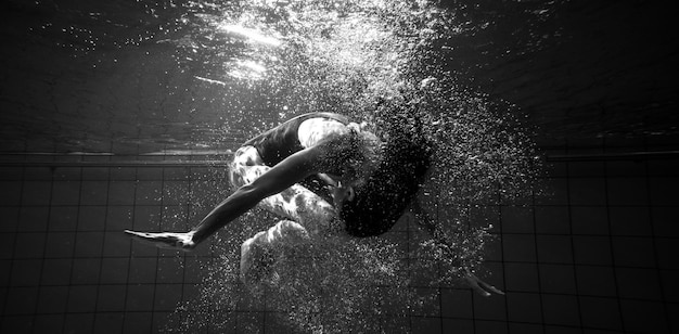 Atletische zwemmer die een salto mort onderwater doet