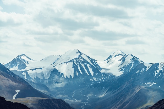 Atmospheric alpine view to big snowy mountains with glacier.