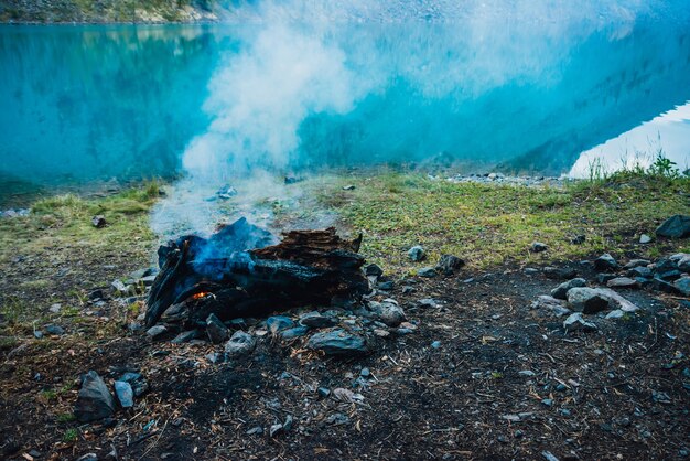 Atmospheric campfire on shore of mountain lake