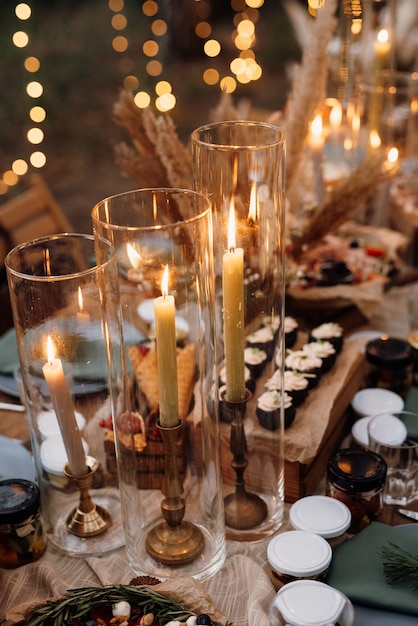 Photo atmospheric candle decor with live fire on the banquet table