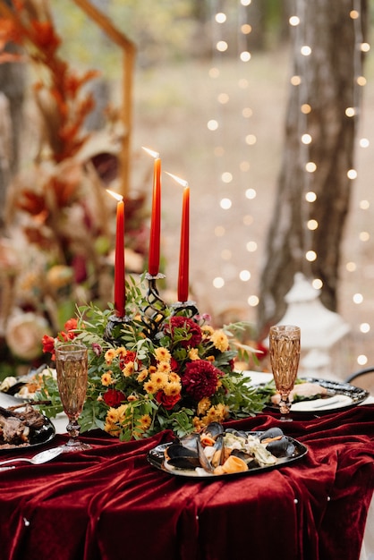 Photo atmospheric candle decor with live fire on the banquet table