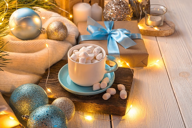 Atmospheric christmas background with a cup of coffee christmas decorations and a gift