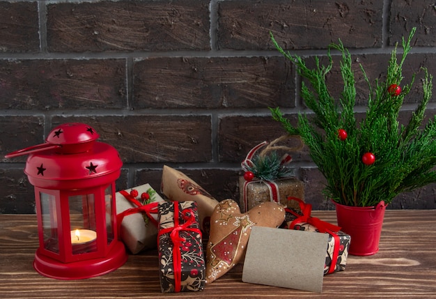 Атмосферная рождественская или новогодняя композиция из сосновых шишек горящая свеча пряники подарки ко ...
