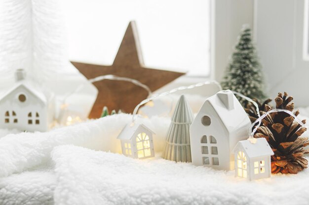 사진 분위기있는 미니어처 겨울 마을 세련된 귀여운 작은 세라 집과 크리스마스 나무 부드러운 눈 개에 빛나는 불빛 크리스마스 현대적인 색 배경 행복한 휴가