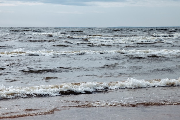 Атмосферный пейзаж Драматическое Балтийское море, волны и брызги воды на волнорезах. Природа северный Cloudscape на побережье океана. Окружающая среда с переменчивой погодой, изменением климата. Бурные абстрактные фоны