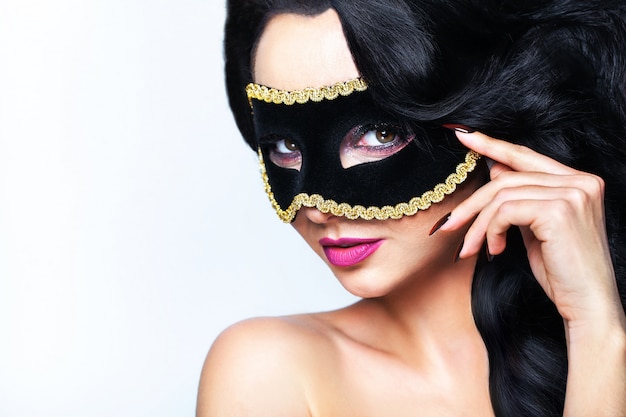 Atractive young woman with venice mask studio portrait.