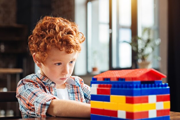 Attent onderzoek. Selectieve focus op een volledig opgeslorpt onderzoeksproces dat zijn aandacht richt op een kleurrijk plastic huis