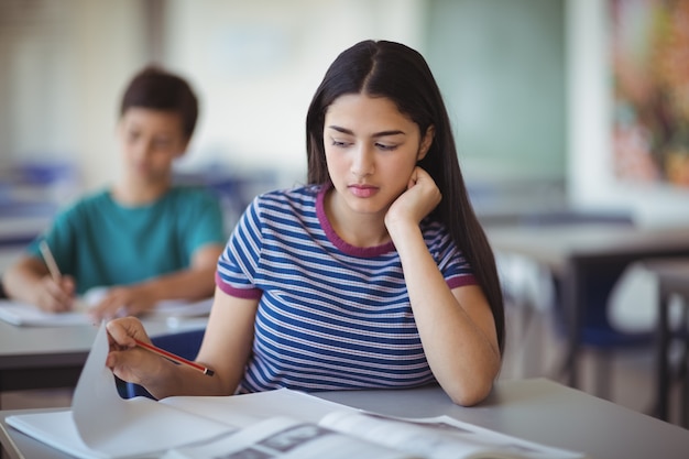 Attent schoolmeisje studeert in de klas