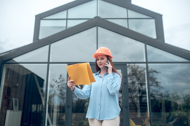 Attente vrouw met document praten via smartphone