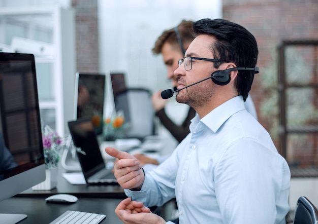 Attente zakenman in koptelefoon zittend aan de tafel callcenterbusiness concept