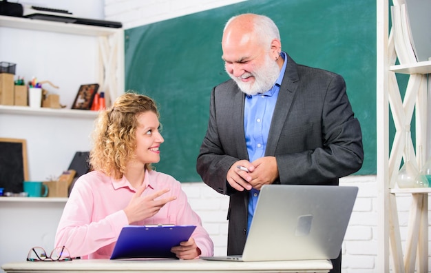 Attention pass exam teachers room senior teacher and woman at school lesson student and tutor with laptop brainstorming on new project working happy student girl with tutor man at blackboard