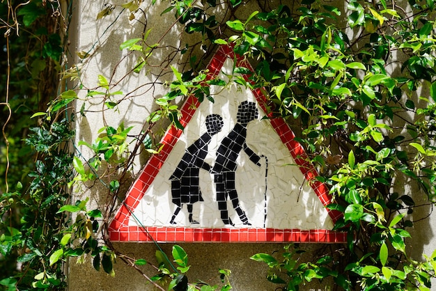 Attention sign passage of the elderly person on tree near\
street road