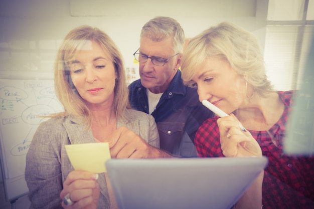 Photo attentive business team looking at a post it