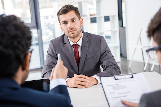 Attentive businessman listening to colleagues during job interview, business concept