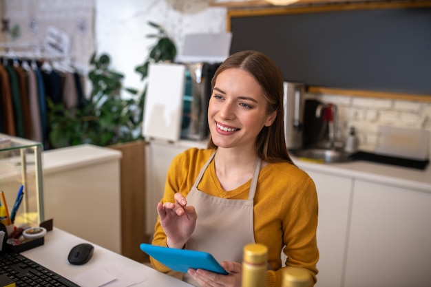 An attentive cafe employee using the tablet for taking order