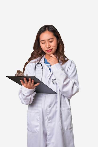 Attentive Chinese woman doctor reading patient report with professional care