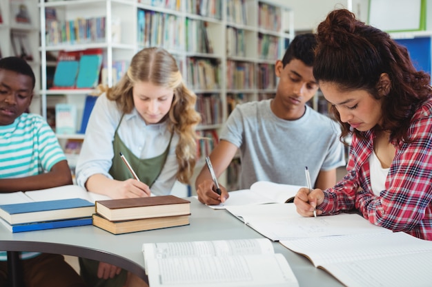 Photo attentive classmates studying in library