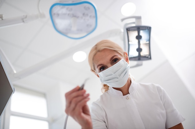 Attentive dentist bending over her patient before beginning the procedure in the morning