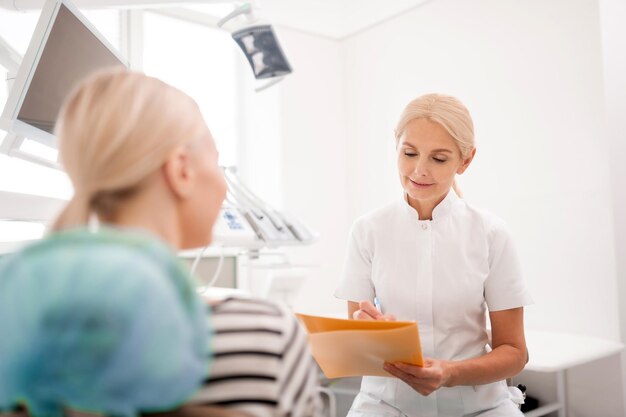 Attentive dentist writing complains of her patient