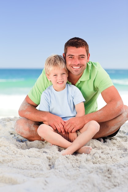 Padre attento con suo figlio in spiaggia