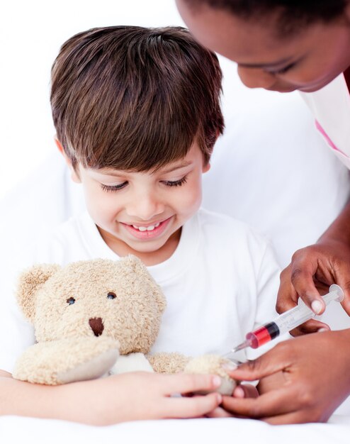 Attentive female doctor playing with a little boy 