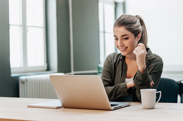 Attentive woman watching media in a laptop.