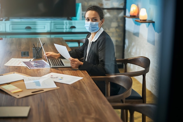 Attentive young woman wearing mask while following the rules of quarantine