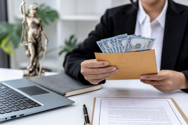 Attorney holding dollars in a brown envelope, she received an attorney's wages from the client after winning the case and completing it. The concept of litigation, law enforcement, law enforcement.