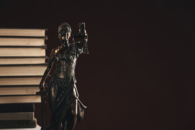 Foto avvocato e notaio concetto. libri in piedi dietro la statua della giustizia.
